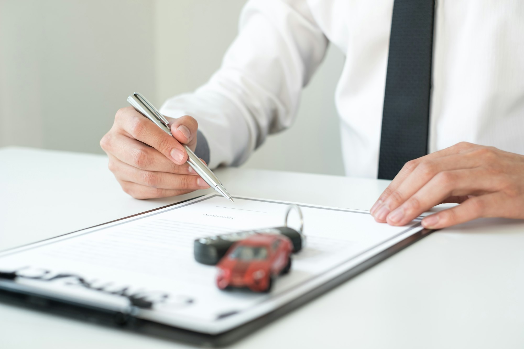 Car dealer businessman holding a car key. Car loan and insurance concept