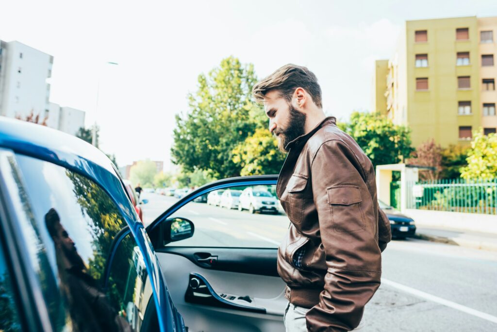 Young bearded man driving car