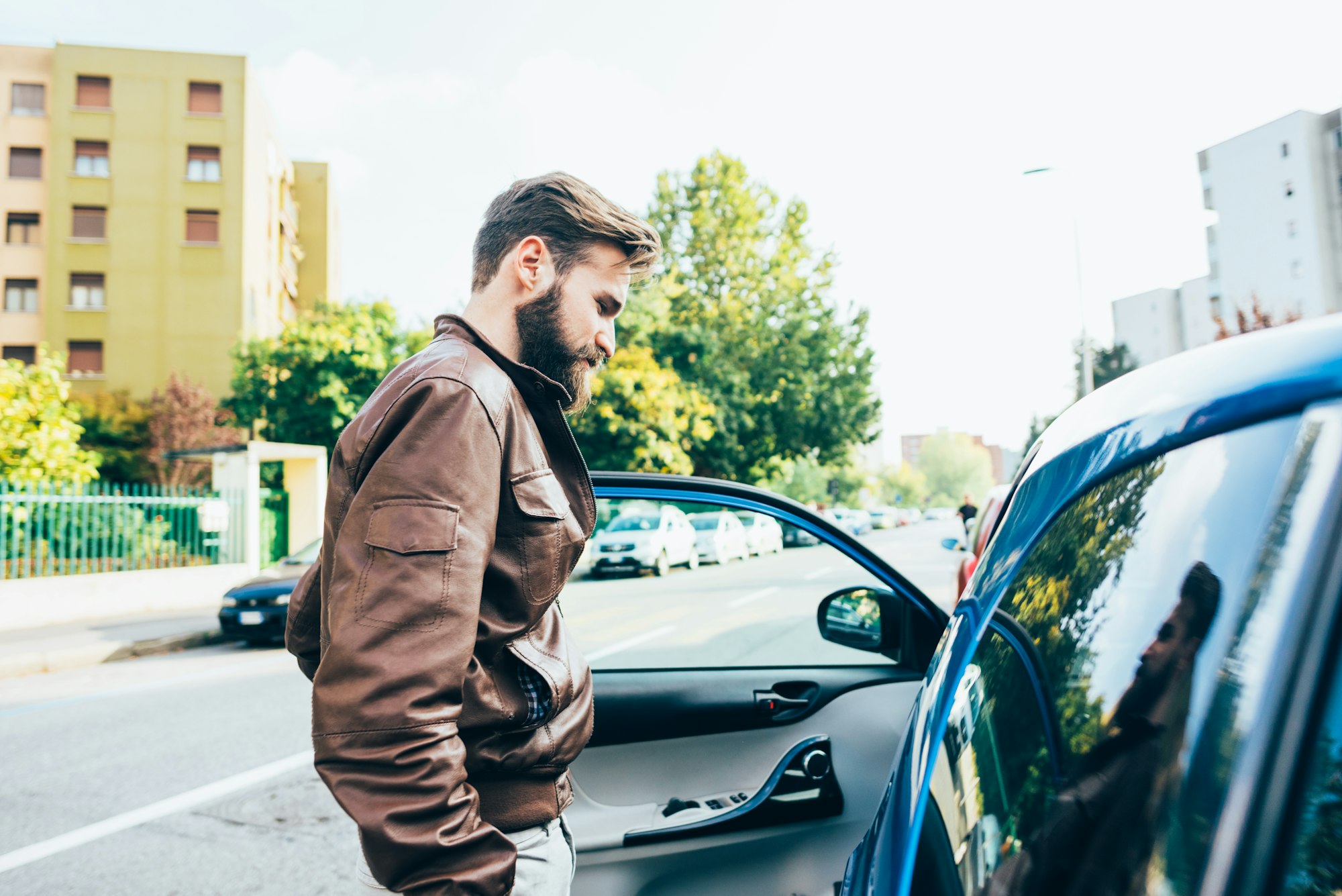 Young bearded man driving car